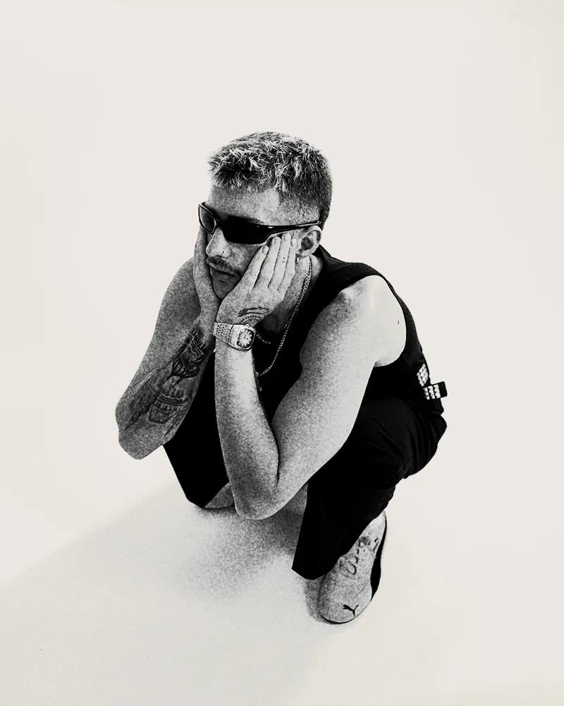 George crouching, head resting in his hands, shot from above, black and white